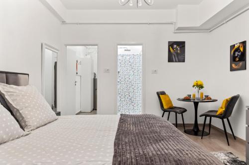 1 dormitorio con 1 cama, mesa y sillas en Brand New Studio - Old Town, en Bucarest