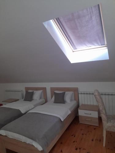 a bedroom with two beds and a skylight at Apartments Gorska in Kolašin