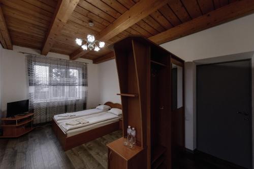 1 dormitorio con cama, ventana y TV en Готель Яблуниця en Yablunytsya