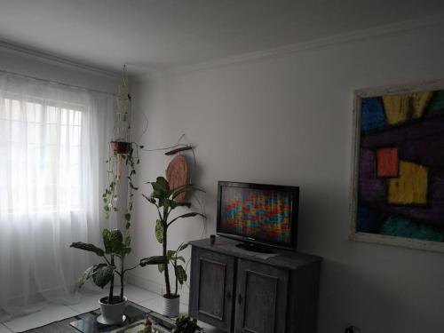 a living room with a flat screen tv on a cabinet at Casa em Balneário Camboriú - próxima à praia in Balneário Camboriú