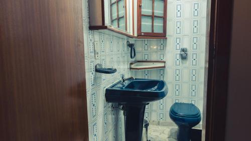 a bathroom with a blue sink and a toilet at Hostel Urbanature in São Paulo
