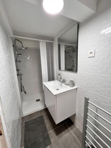 a white bathroom with a sink and a shower at Chalet Millou Beuil in Beuil