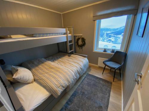 ein Schlafzimmer mit einem Etagenbett und einem Stuhl in der Unterkunft New modern apartment with great view - ski in & out in Skulestadmo