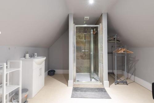 uma casa de banho com um chuveiro no sótão em Milestone House em Somersham