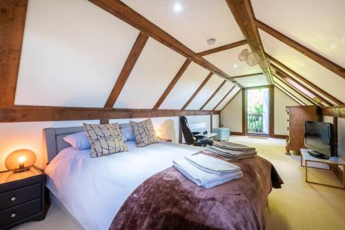 um quarto com uma cama grande e uma televisão em Milestone House em Somersham