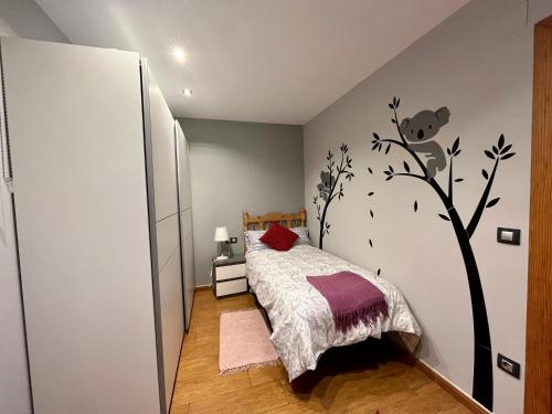 een slaapkamer met een bed met een muurschildering van bomen aan de muur bij Zayas enea in Elizondo
