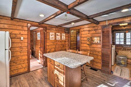 a kitchen with wooden walls and a refrigerator and a counter at Rustic Lake Harmony Home with Fire Pit and Hot Tub! in Lake Harmony