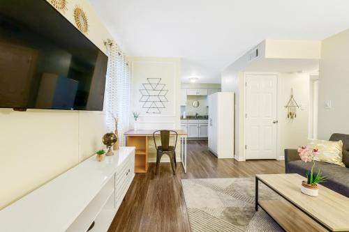 a living room and kitchen with a couch and a table at Dapper Digs - King Bed - Long Term Stays - Duke in Durham