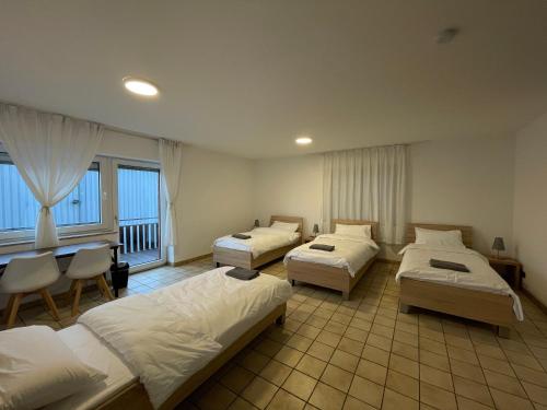 a hotel room with three beds and a table and chairs at Erft Apartment in Kerpen