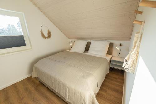 een kleine slaapkamer met een bed en een raam bij Das Seehaus in Nordhorn