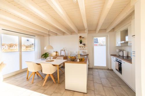 een keuken en eetkamer met een tafel en stoelen bij Das Seehaus in Nordhorn