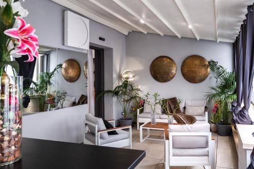uma sala de estar com cadeiras brancas e planetas na parede em Daphne Luxury Suites em Roma