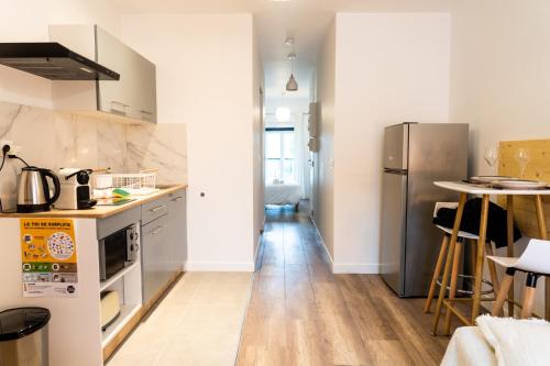 uma cozinha com um frigorífico e uma bancada em Magnifique T2 centre ville dernier étage avec balcon em Valence