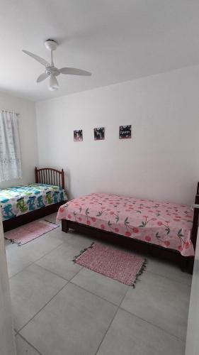 - une chambre avec 2 lits et un ventilateur de plafond dans l'établissement Cond Cristal Indaiá I Ap23, WI-FI, 450m praia Indaiá, check-out 16h, à Bertioga