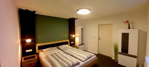 1 dormitorio con 1 cama con pared verde en Ferienwohnung Stohn, en Pirna