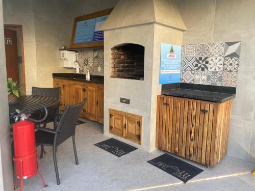 a kitchen with a stove and a table with chairs at Temporada Ilhéus 2/4 in Ilhéus