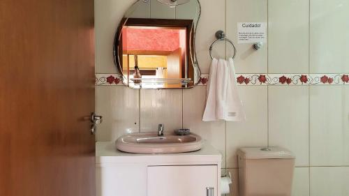 ein Badezimmer mit einem Waschbecken, einem Spiegel und einem WC in der Unterkunft Casa Palace Canela in Canela