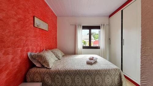 a small bedroom with a red wall at Casa Palace Canela in Canela