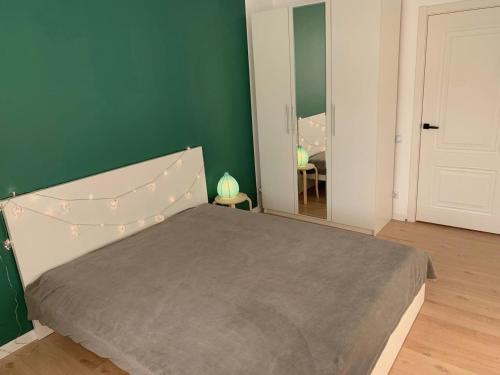 ein Schlafzimmer mit einem Bett und einer grünen Wand in der Unterkunft Olive Home in Oral