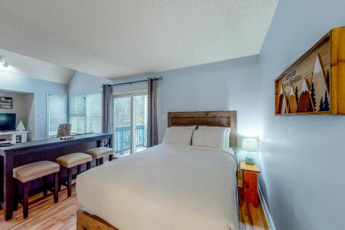 Un dormitorio con una gran cama blanca y un escritorio. en Condo 110 at North Creek Resort, en Blue Mountains