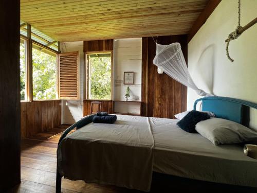 een slaapkamer met een bed met een net erin bij Old Bocasso in Bocas del Toro