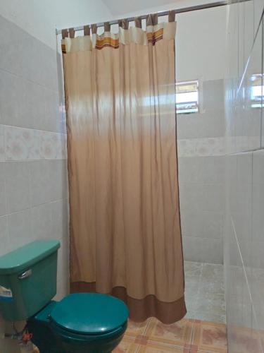 a shower curtain in a bathroom with a toilet at Hotel Posada Quetzal in Arriaga