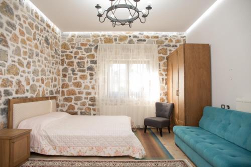 - une chambre avec un lit et un canapé dans l'établissement Luxury Villa Saint Nikolas, à Voskopojë