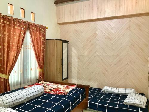 a room with two twin beds and a window at Villa Sakana - Escape to Paradise in Balong