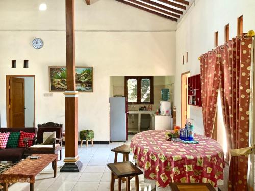 a living room with a table and a kitchen at Villa Sakana - Escape to Paradise in Balong