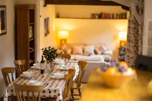 une table à manger et des chaises avec un canapé dans un salon dans l'établissement The Byre, à Goodleigh