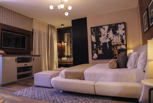 a bedroom with a bed and a couch and a tv at Hotel Boutique Corazón Mexicano in Guanajuato