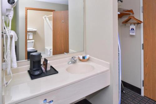 a bathroom with a sink and a mirror at Regency Inn Geneseo IL I-80 in Geneseo
