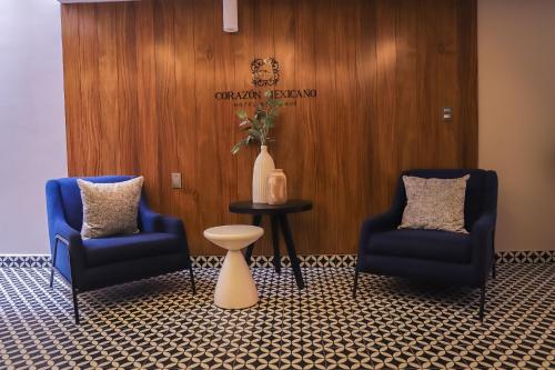 a waiting room with two chairs and a table and a vase at Hotel Boutique Corazón Mexicano in Guanajuato