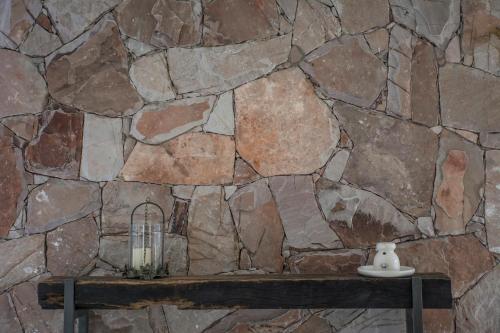 a stone wall with a candle on a table at Terra Campo Posada in Chacras de Coria