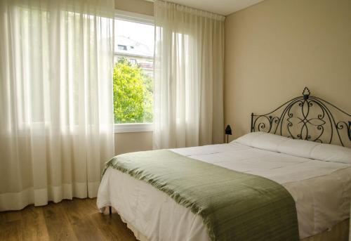 um quarto com uma cama grande e uma janela em Departamento con vista em San Carlos de Bariloche
