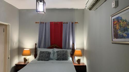 N & A PALACE في خليج مونتيغو: غرفة نوم مع سرير مع مصباحين على الطاولات