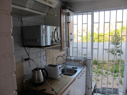 cocina con fregadero, microondas y ventana en Casa Independiente Serena Oriente en Coquimbo