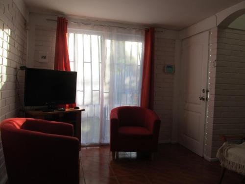 sala de estar con TV y silla roja en Casa Independiente Serena Oriente, en Coquimbo
