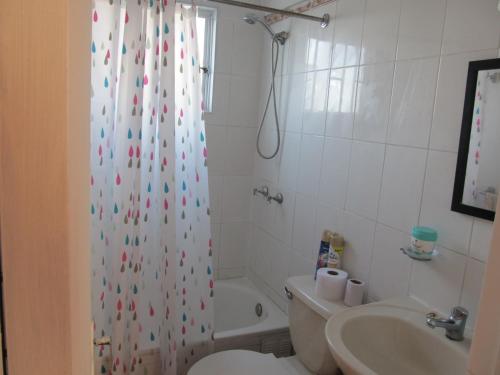 y baño con cortina de ducha, aseo y lavamanos. en Casa Independiente Serena Oriente en Coquimbo