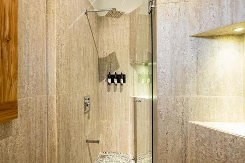 a shower with a glass door in a bathroom at Cafe Playa Negra Hotel in Playa Negra