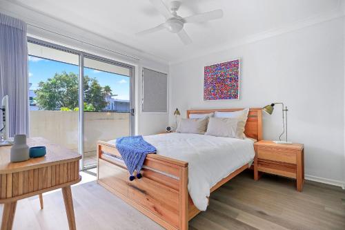 een slaapkamer met een bed en een groot raam bij Coastal Cove Huskisson in Huskisson