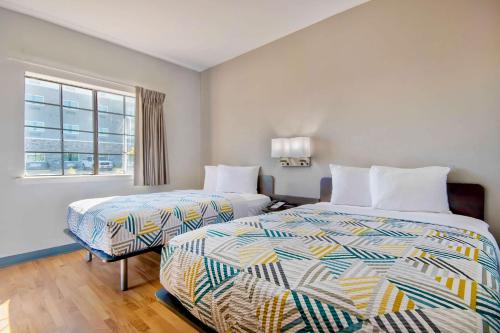 a hotel room with two beds and a window at Studio 6-Port Arthur, TX - SE in Port Arthur