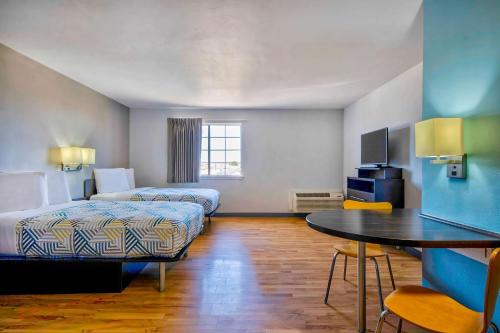 Habitación de hotel con 2 camas y mesa en Studio 6-Port Arthur, TX - SE, en Port Arthur