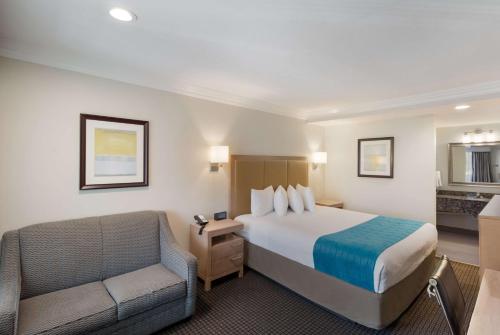 ウッドランド・ヒルズにあるBest Western Woodland Hillsのベッドと椅子付きのホテルルーム