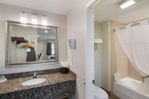 bagno con lavandino, servizi igienici e specchio di Best Western Woodland Hills a Woodland Hills