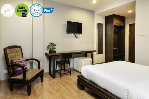 1 dormitorio con 1 cama, escritorio y TV en Chiang Mai Thai House,Thapae en Chiang Mai