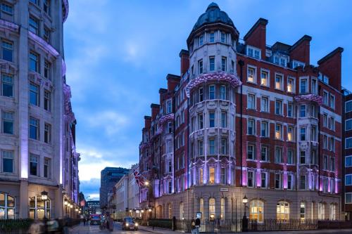 Radisson Blu Kenilworth Hotel, London في لندن: مبنى كبير على شارع المدينة عند الغسق