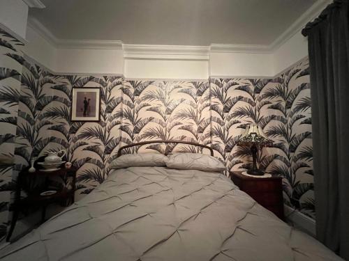 1 dormitorio con 1 cama grande y papel pintado grande en Westend en Ryde