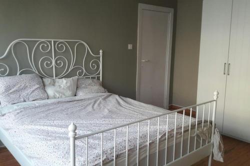 a bedroom with a white bed with a metal headboard at charming house with 3 bedrooms & terrace 10 minutes from city centre in Antwerp
