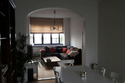 een woonkamer met een bank en een tafel bij charming house with 3 bedrooms & terrace 10 minutes from city centre in Antwerpen